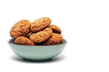 fresh tasty oatmeal cookies in a turquoise plate on a white background