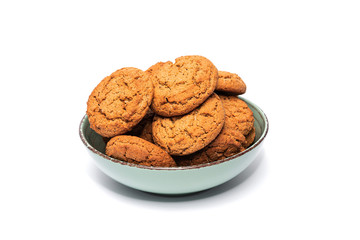 fresh tasty oatmeal cookies in a turquoise plate on a white background