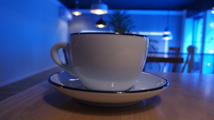 Big white cup of coffee or cappuccino drink on a table in a restaurant
