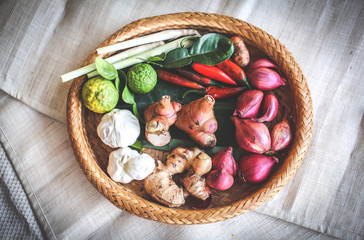 Fototapeta na wymiar Lime, garlic, ginger, chilli and spring onion in basket 