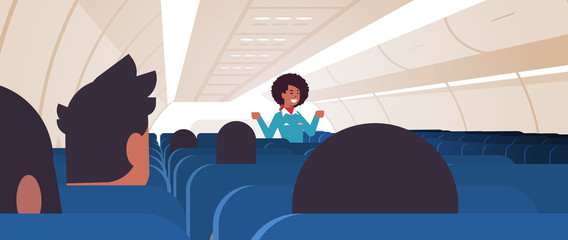 stewardess explaining instructions for passengers african american flight attendant in uniform showing emergency exits safety demonstration concept airplane board interior horizontal vector