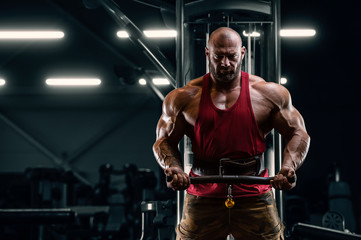Fototapeta na wymiar Bodybuilder handsome strong athletic man pumping up biceps