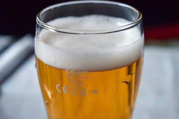 Glass transparent glass with light beer with a large layer of foam