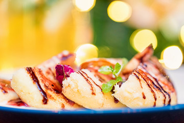 Cottage cheese pancakes or syrniki with cream, fruit jam and flower decoration
