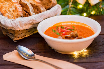 Plate with freshly cooked tomato soup with sausage served with bread