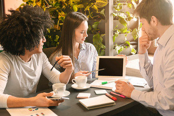 Woman showing information on tablet screen to colleagues