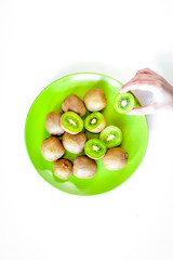 fresh green fruits with kiwi on on plate white background top view