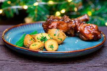 Roasted chicken quarter legs with baked potato on rustic background