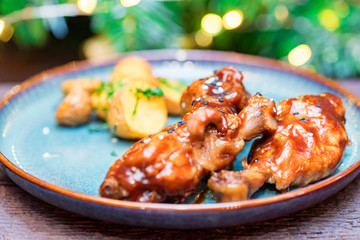 Roasted chicken quarter legs with baked potato on rustic background