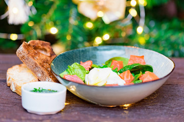 Bowl with salmon salad with poached egg, bread and sauce