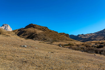 Rocks and dry grass in North Caucasus mountains in autumn on sunny day