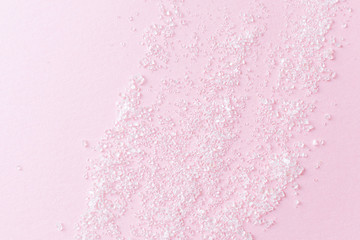 Sugar sprinkled on a pink surface. Fly Lay, minimalism, copyspace, top view. Unhealthy sweet food concept.