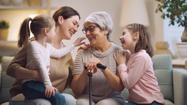 A nice girls, their mother and grandmother enjoying spending time together. Good time at home. Family playing in the living room.