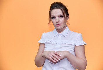 Obraz premium Business concept. Close-up portrait of an adult pretty woman of 40 years old with good makeup in a business suit on a yellow background. Standing right in front of the camera with a smile.