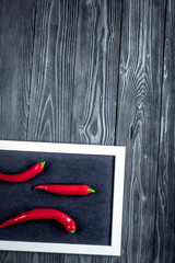 red chili pepper frame design on dark table background top view mock-up