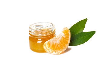 Isolated slice of tangerine with tangerine jam and green leaves on a white background