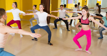 Fototapeta na wymiar Tweens exercising with coach in choreography class