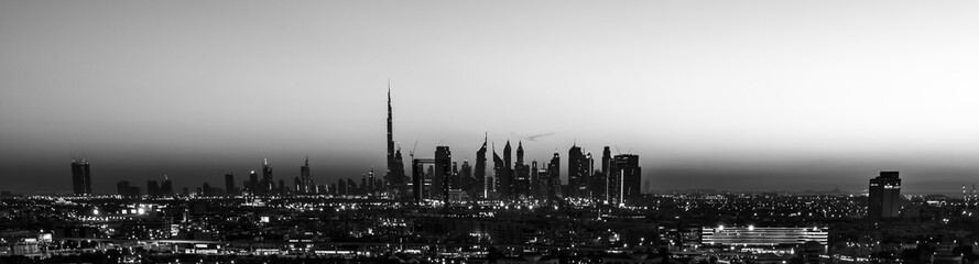 Fototapeta na wymiar Dubai sunset in black and white view from the creek and sihouette of the cityscape 