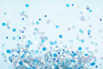 Colorful festive confetti scattered on blue pastel background. Flat lay style. Holiday concept.