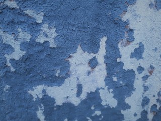 close-up of a decorative wall with bokeh effect and characteristic rough porous texture, abstract dark and light spots on a classic blue background