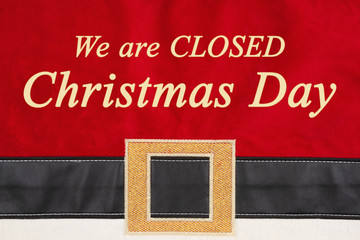 Fototapeta na wymiar Closed Christmas Day message on red and black Santa suit