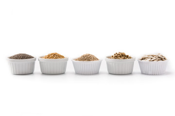 Assortment of different seeds in bowl isolated on white background. Pumpkin, linen, chia, sunflower, and sesame seeds