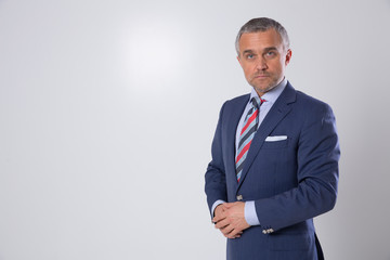A portrait of a man on a matte brown wall in the background. A businessman.