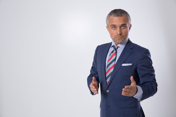 A portrait of a man on a matte brown wall in the background. A businessman.