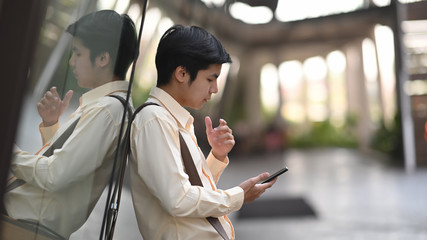 Businessman using his smartphone waiting travel.