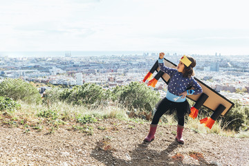 girl poses joking like a superhero with costume