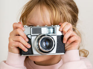 Child holds nostalgia camera in hands