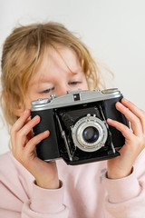 Child holds nostalgia camera in hands