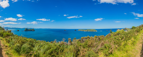 Panoramic view over cliffy shore of Te Whanganui-A-Hei Marine Reserve on Northern island in New Zealand in summer