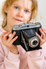 Child holds nostalgia camera in hands