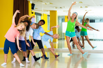Fototapeta na wymiar Cheerful little children studying modern style dance in class