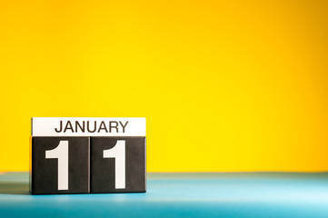 January 11th. Day 11 of january month, calendar on yellow background. Winter time. Empty space for text