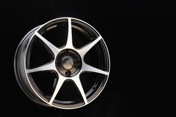 Shiny cast disc with thin sports spokes and polished aluminum surface on a dark background...