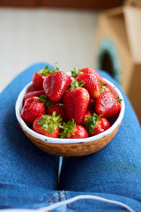 woman holding a bowl of freshly red strawberries