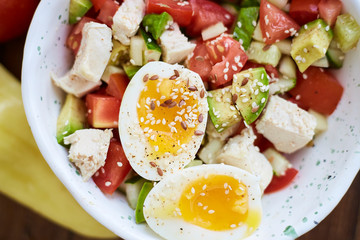 Summer salad with fresh vegetables, avocado and eggs