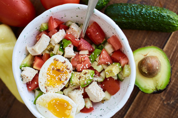 Summer salad with fresh vegetables, avocado and eggs