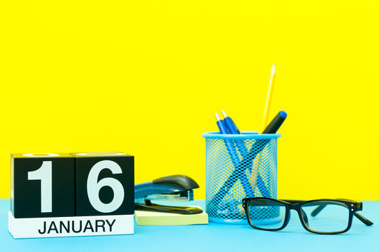 January 16th. Day 16 of january month, calendar on yellow background with office supplies. Winter time