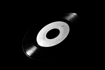 45 rpm vinyl disk with white label on dark background