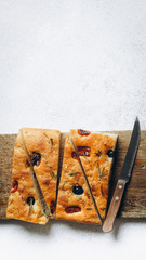 Traditional Italian Focaccia with tomatoes, olives and rosemary - homemade flat bread focaccia.