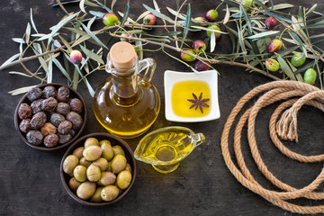 Mixed types of olive in the bowls and olive oil on the table