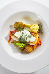 Cod Fillet with Baked Vegetables on White Restaurant Plate Isolated