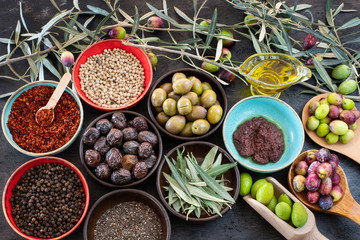 Mixed types of olive in the bowls and olive oil on the table