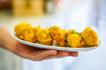 mão a servir pasteis de bacalhau