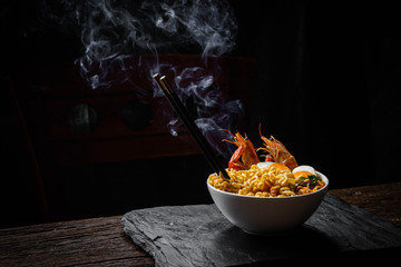 Tom Yam Tom Yum Kung with noodles, arranged with shrimp Peat, steam, heat and eggs and coriander Chopsticks on the side - Thai food concept