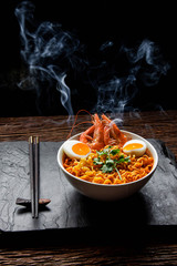 Tom Yam Tom Yum Kung with noodles, arranged with shrimp Peat, steam, heat and eggs and coriander Chopsticks on the side - Thai food concept