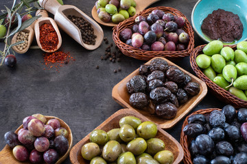 Mixed types of olive in the bowls and olive oil on the table